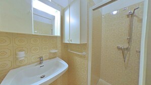 Ein Badezimmer mit Waschbecken, Spiegel und Dusche.