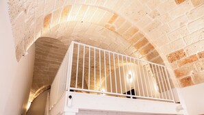 A white balcony with a metal railing, a stone ceiling, and a white wall. - Pachita Seaside Rooms (Polignano a Mare)