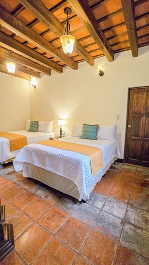 A room with two beds, a wooden ceiling, and a tiled floor. - Hotel Casa Colonial by AHS (Antigua Guatemala)