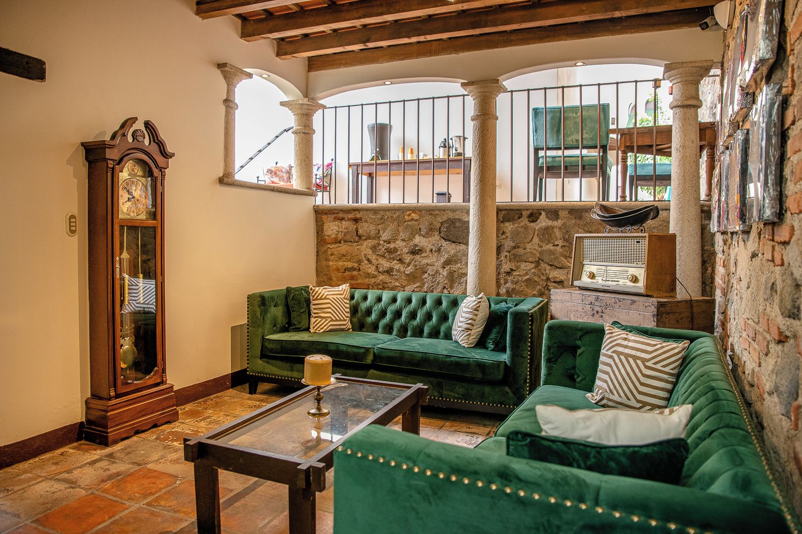 Una sala de estar acogedora con un sofá verde, una mesa de centro de madera y un gran reloj de pie.