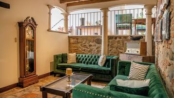 Una sala de estar acogedora con un sofá verde, una mesa de centro de madera y un gran reloj de pie.