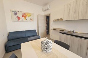 A modern kitchen with a sink, cabinets, and a decorative vase on the table. - Apartment 4 - Diletta's Residence (Sant'Isidoro)