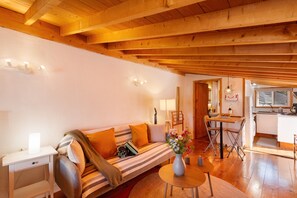A cozy living room with a sofa, a small table, and a dining area. - Vacation Home 'Arguineguín Retreat' with Mountain View, Wi-Fi and Air Conditioning (San Bartolomé de Tirajana)