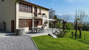 A two-story building with a balcony, a patio with outdoor furniture, and a view of the surrounding landscape. - ThreeZeroThree House • With Private Garden (Colombaro)