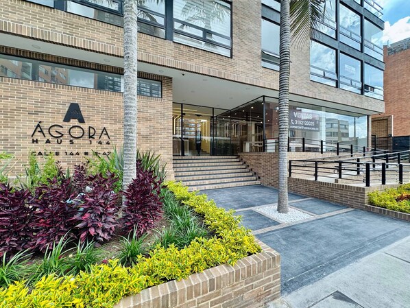 A modern building with a sign reading 'ÁGORA HAU5 144'.