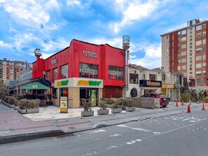 Un restaurant Subway à la façade rouge, situé à côté d’un immeuble sur lequel on peut lire l’enseigne « Similao » et où se trouve un salon de beauté appelé « Murano ».
