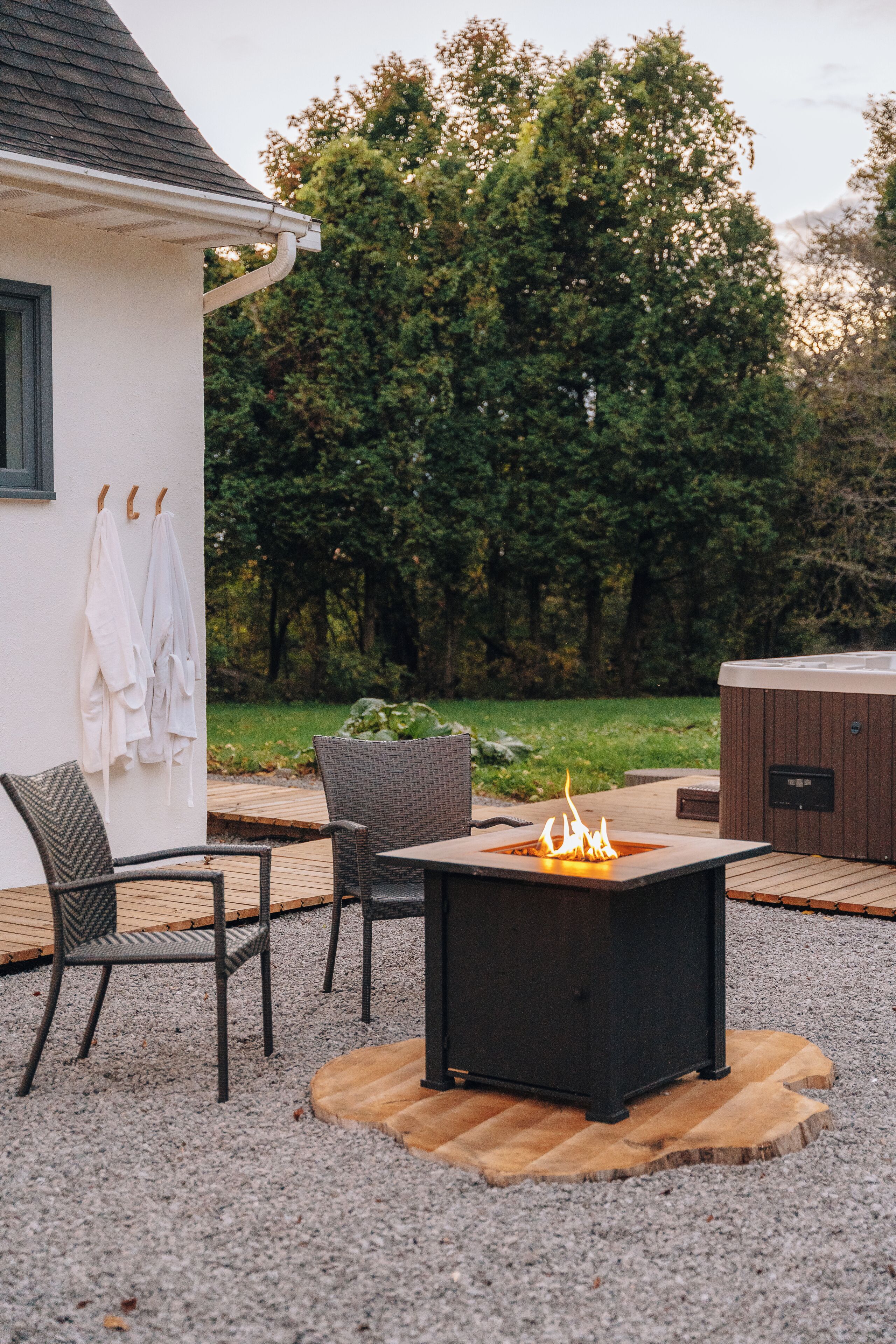 A patio with a fire pit, outdoor seating, and a hot tub.