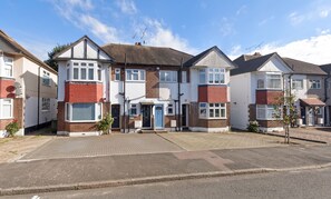 A row of two-story houses with a central entrance, brick facades, and satellite dishes. - Modern Ground Floor Flat w Parking Romford (Greater London)
