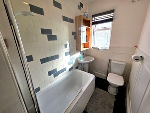 A bathroom with a bathtub, toilet, and sink. - Modern Ground Floor Flat w Parking Romford (Greater London)