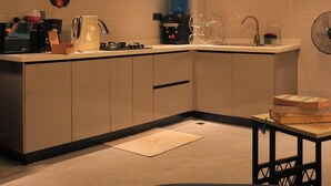 Une cuisine compacte dotée d’appareils électroménagers modernes, d’un four encastré et d’un four à micro-ondes.