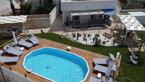 A rooftop swimming pool with lounge chairs, a covered seating area, and a garden with cacti and plants. - Apartment 5 - Diletta's Residence (Sant'Isidoro)