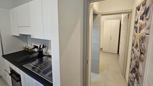 A modern kitchen with white cabinets, a black countertop, and a stainless steel sink. - Apartment 5 - Diletta's Residence (Sant'Isidoro)