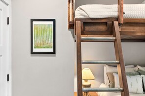 A bunk bed with a ladder, a framed painting on the wall, and a bedside lamp. - Cozy Luxury Farmhouse, Minutes To Downtown & BRPW (Asheville)