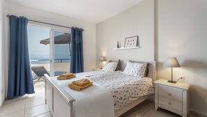 A bedroom with a bed, nightstands, a window with curtains, and a view of the outdoors. - Vacation Home 'Vistamar-lovely Renovated With' with Wi-Fi (La Matanza de Acentejo)