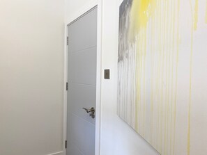 A hallway with a closed door and a wall with vertical lines. - Coniston House by Guestz (Appleby-in0Westmorland)