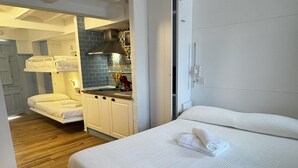 Una habitación de hotel con cama, kitchenette y baño.