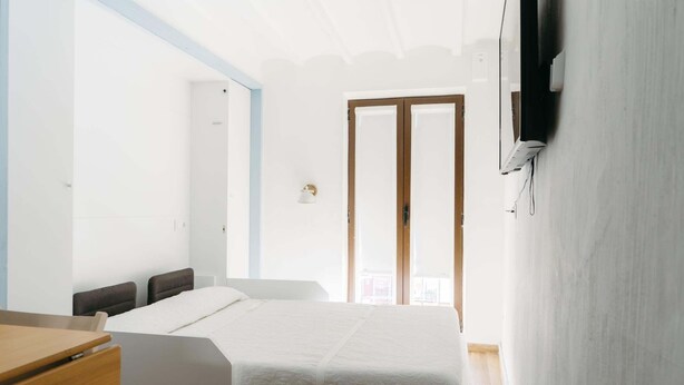 Un dormitorio con cama, escritorio y armario.