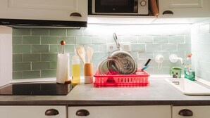 A kitchen with white cabinets, a microwave, a dish rack, and a sink. - Pinot Noir Harbor's Light (La Vila Joiosa)