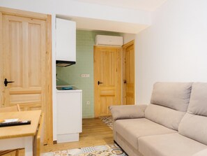 A compact living space with a kitchenette, a sofa, and a dining area. - Pinot Noir Harbor's Light (La Vila Joiosa)