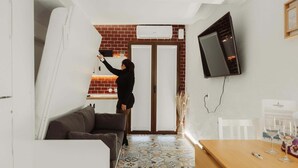 Un salon moderne avec un canapé, un téléviseur fixé au mur et un sol à motifs.