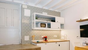 Una cucina moderna con mobili bianchi, un forno a microonde e un piano di lavoro in legno.