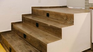 Una scala con gradini in legno e una parete bianca.