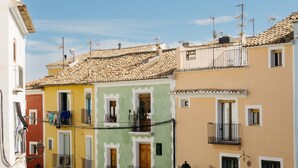 Una calle estrecha con edificios coloridos, balcones y antenas parabólicas.