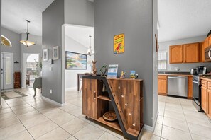 Una cocina moderna con armarios de madera, lavavajillas y una encimera con cafetera.