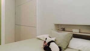 A bedroom with a bed, pillows, a nightstand, and a wardrobe. - Malvasia Harbor's Light (La Vila Joiosa)