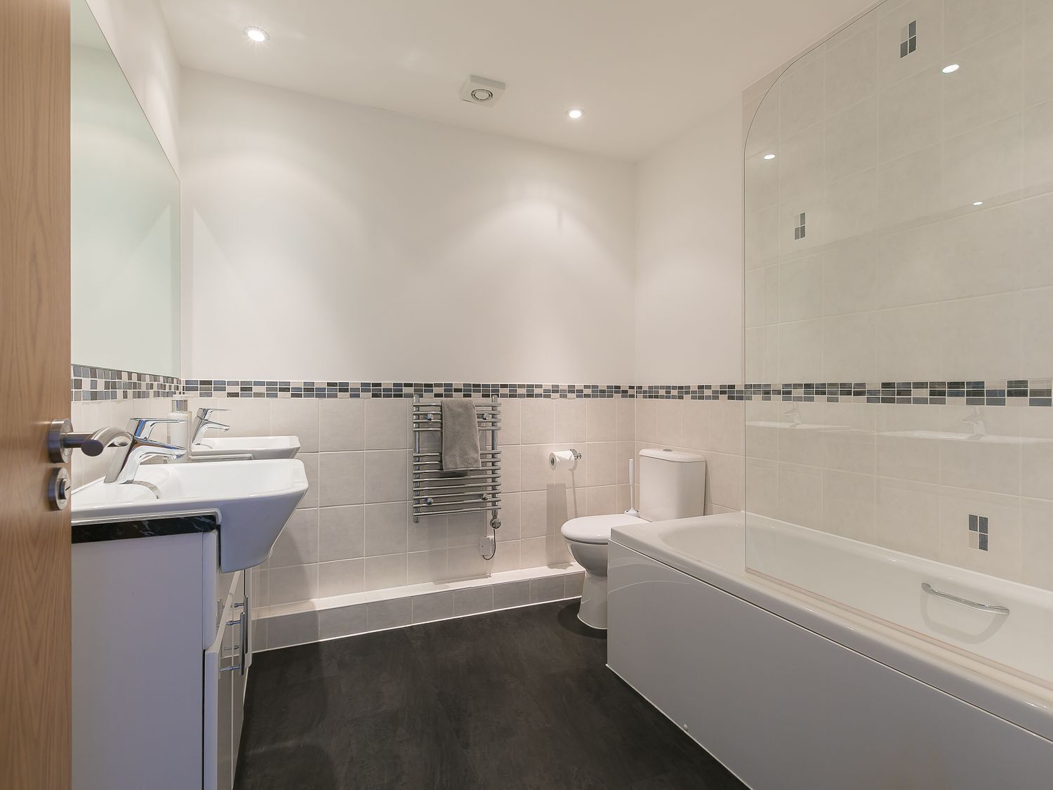 Un baño moderno con lavamanos, inodoro y bañera.