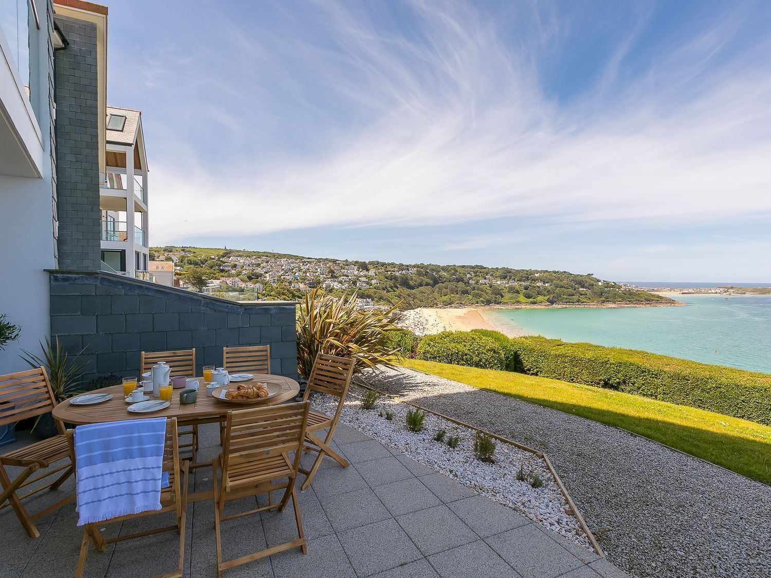 Un patio con una mesa lista para el desayuno, con vista al mar.