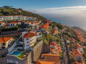 Eine Küstenwohngegend mit Reihenhäusern, einem Schwimmbad und Blick auf das Meer.