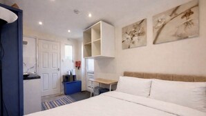 A bedroom with a bed, a desk, and a wardrobe. - Modern compact Studio APT near City Centre (Essex)