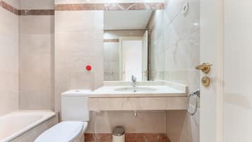 A bathroom with a toilet, sink, and mirror.