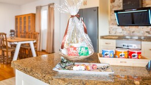 A kitchen counter with a basket of packaged snacks, a tray with lollipops, and a wooden box labeled 'OUTIN'. - Villa Horizonte with Sea Views, Wi-Fi and Air Conditioning (Tijoco Bajo)