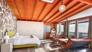 A bedroom with a bed, a sofa, and a view of the outdoors. - Villa Horizonte with Sea Views, Wi-Fi and Air Conditioning (Tijoco Bajo)