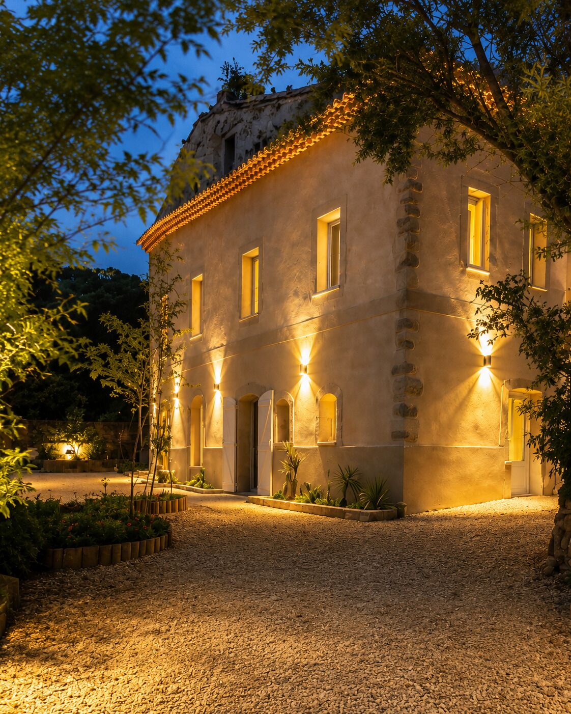 A building with multiple windows and a gravel driveway.