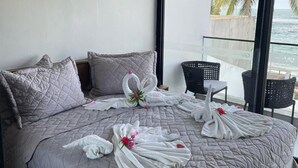 A hotel room with a large bed, a balcony with a view of the sea, and an air conditioning unit on the wall. - Porto 2 Life Resort (Ipojuca)