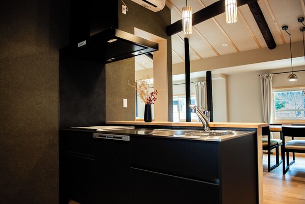 A modern kitchen with a central island, built-in appliances, and pendant lighting.