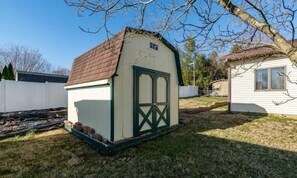 A small, single-story shed with a sloped roof and a green door. - Sleeps 16+ • 5BR • Game Rooms • Near IU/Indy/Lake (Perry Township)
