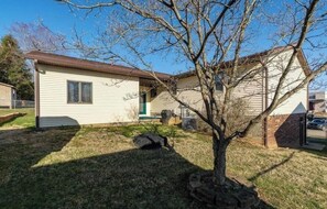 A single-story house with a front porch, a small garage, and a tree in the yard. - Sleeps 16+ • 5BR • Game Rooms • Near IU/Indy/Lake (Perry Township)