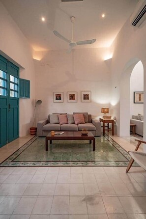 A living room with a sofa, coffee table, and ceiling fan. - Rumi a perfect home near the PASEO GASTRONOMICO (Mérida)