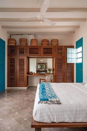 A bedroom with a bed, wooden wardrobe, and a desk with a chair. - Rumi a perfect home near the PASEO GASTRONOMICO (Mérida)