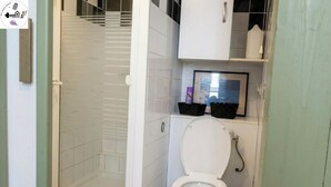 Un baño con inodoro, ducha y lavamanos.
