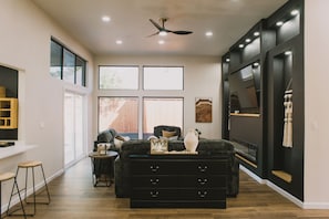 A spacious room with a large window, a ceiling fan, and a black dresser. - Modern Pool Retreat: Mid & Long-Term Stays Dallas (Dallas)