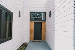 A modern building with a wooden door and a window above it. - Modern Pool Retreat: Mid & Long-Term Stays Dallas (Dallas)
