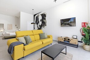 Ein modernes Wohnzimmer mit einem gelben Sofa, einem schwarzen Couchtisch und einem minimalistischen Design.