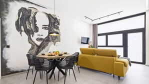Ein zeitgemäßer Wohnraum mit Essbereich, einer Couch und einem großen Fenster.