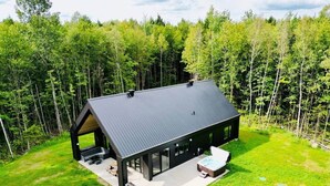 Una casa moderna con una amplia terraza, un jacuzzi y un espacio exterior cubierto.