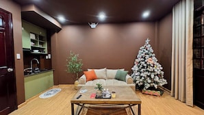 Una sala de estar con sofá, mesa de centro y un árbol de Navidad.